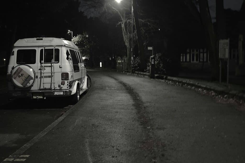 A van parked on the side of a road at night